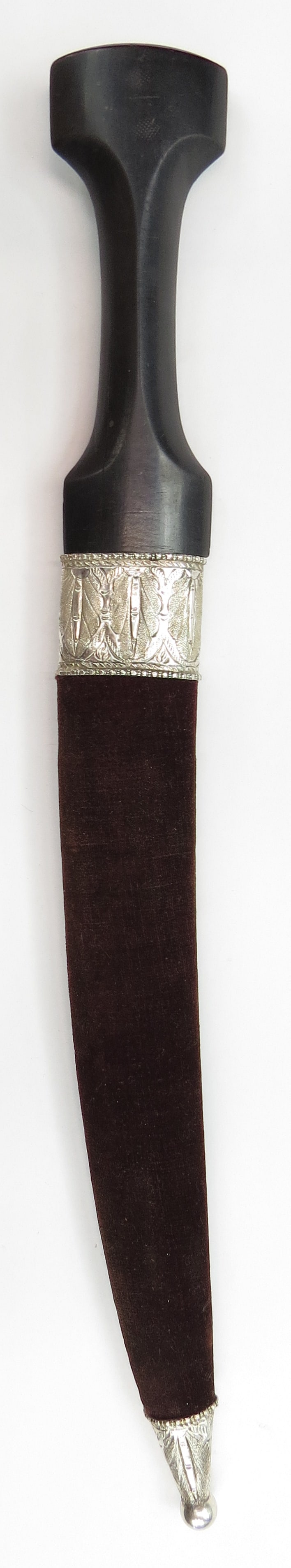 AN OTTOMAN HANCER DAGGER: Baghdad work. The ebony grip of characteristic form, the curved, double-edged wootz blade with complex pattern, with distinct central ridge and gold-inlaid vegetal panels at the forte. In its velvet-c