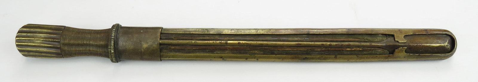 A RARE BHUTANESE DAGGER: The straight single-edged blade showing layered construction, with short back edge. The hilt wrought entirely in brass with fluted pommel and wire-wrapped grip. The wooden scabbard with pierced and pr