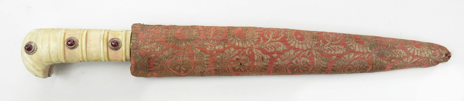 AN INDIAN KARD DAGGER: A massive example of characteristic form carried in the sash, the bone grips ribbed and set with three rubies in silver settings on each side. The tangbands and integral bolster intricately inlaid in