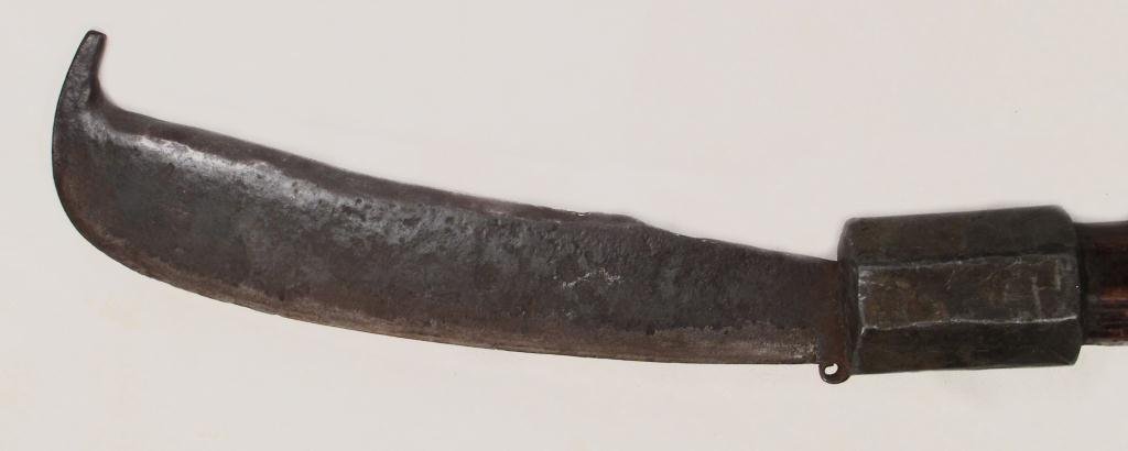 A RARE BALINESE KUDI AXE: The massive, single-edged blade with peaked terminal and a polygonal lead collar affixed to the base to increase momentum when swung. On its original faceted, tapering haft.18th-19th century.Overall l
