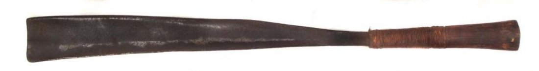 A NAGA DAO SWORD: The wooden grip with rattan wrap, heavy handforged blade with single edge. Second half of the 19th century.Generally worn.Overall length 59.8 cm. Condition III