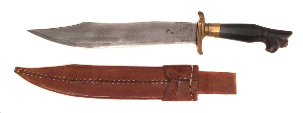 A PHILIPPINES DAGGER: The horn grip with flared pommel, brass guard and broad blade with clipped tip struck with a maker?s mark. In its leather scabbard.WW2-era. Light wear. Overall length 42 cm. Condition II