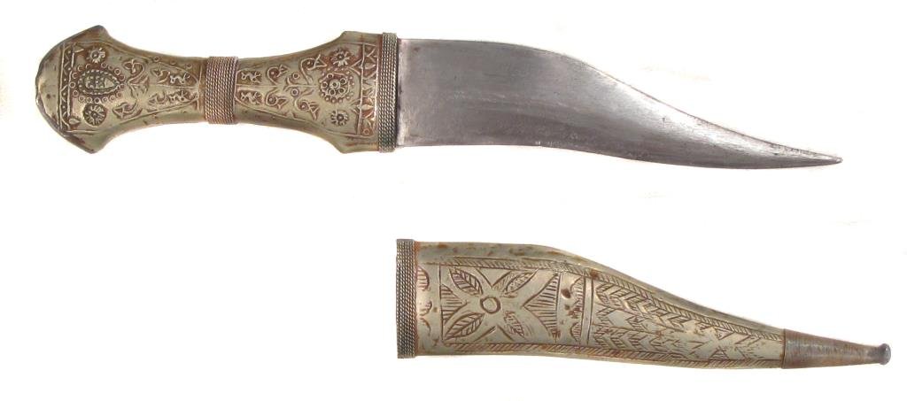 A SYRIAN KHANJAR DAGGER: With embellished white metal mounts and recurved blade. In its matching scabbard.Mid-20th century.Overall length 29.1 cm. Condition I