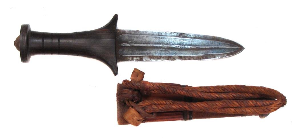A SUDANESE ARM DAGGER: With hardwood handle and broad blade, the leather scabbard with braided armband. Late 19th century .Overall length 22.7 cm. Condition I