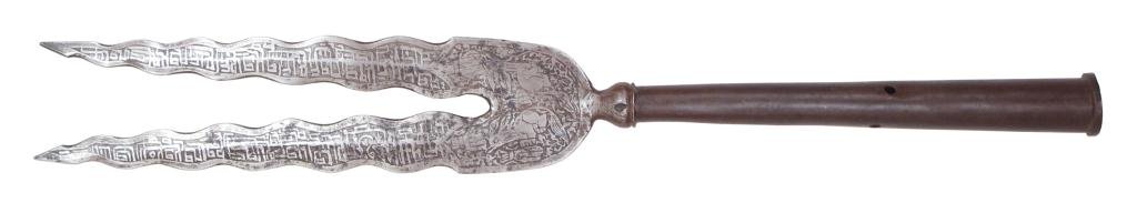 A PERSIAN BIDENT SPEAR: With bifurcate blades, each with flamboyant edges and a central ridge, elaborately etched overall with Arabic inscriptions and animals at the forte. Socket of expanded form with rounded baluster base.