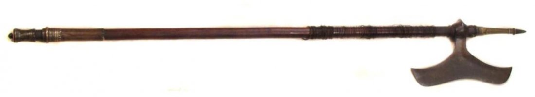 A RARE INDIAN BATTLEAXE: A form endemic to the Bhil people of Central India, the steel head forged with a convex bit, the socket wrought with a pronounced flange. On its hardwood haft with brass mounts .Latter 18th century. M