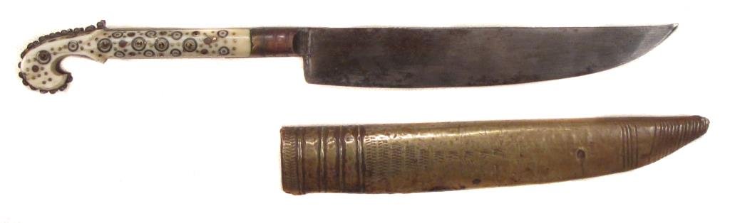A BOSNIAN DAGGER: The bone grip with rolled pommel, elaborately inlaid with brass studs and rosettes, the broad, well-forged blade struck with a maker?s mark in the form of a saber. In its brass-covered wooden scabbard
