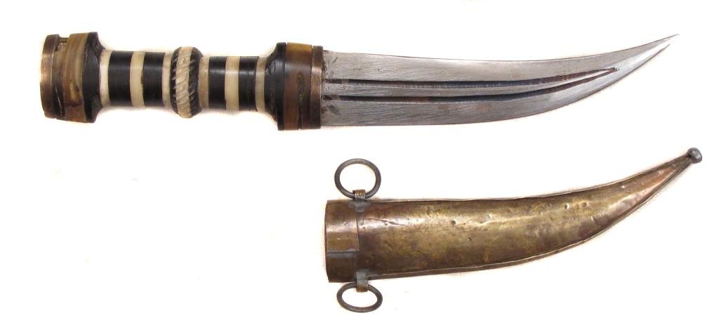 A SYRIAN KHANJAR DAGGER: The horn grip inlaid in geometrical motifs. With curved steel blade and brass scabbard. Late 19th-early 20th century.Overall length 28.5 cm. Condition II