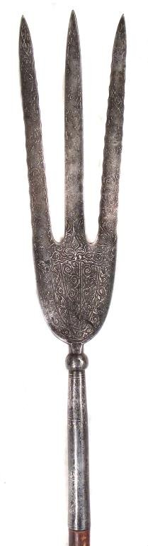 A PERSIAN TRIDENT SPEAR: The steel head forged with three blades, the outer ones undulating, inlaid overall with running vine motifs in silver. On its hardwood haft.Late 19th century.Overall length 151.1 cm. Condition II