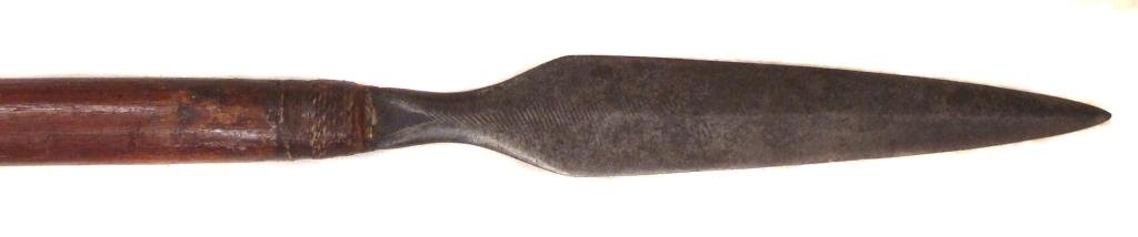 A RARE MORO SPEAR: The head of characteristic form, wrought from a captured European file as was typical during the latter Spanish colonial era. Retained to the well-patinated hardwood haft with rattan.Late 19th century