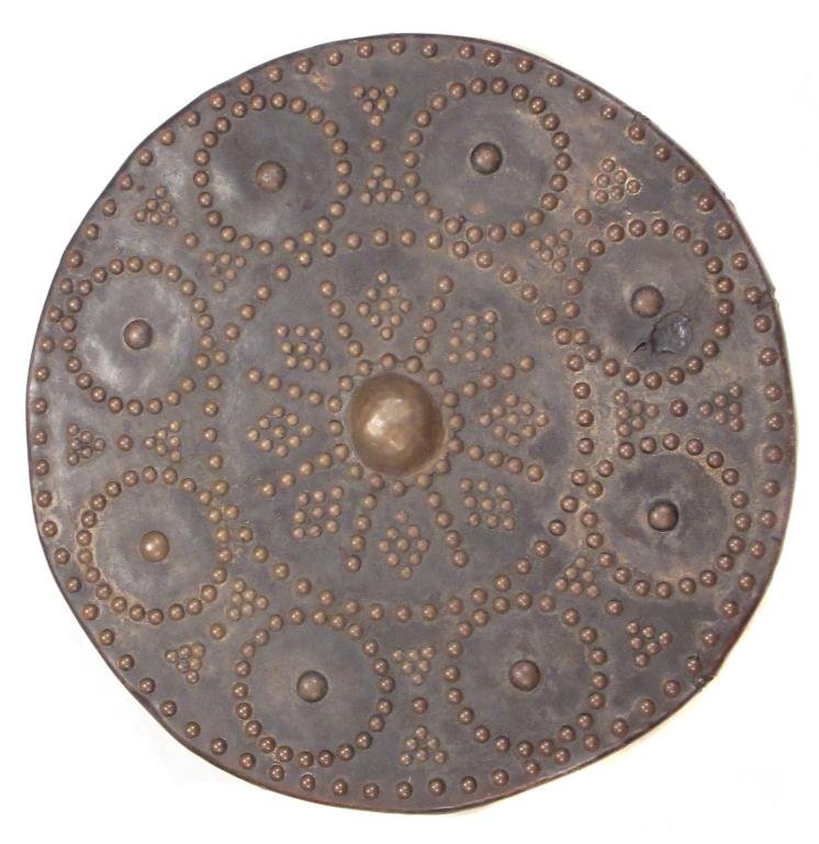 A RARE SCOTTISH TARGE SHIELD: Very seldom encountered, of characteristic planked construction, covered in deeply-patinaed leather. The surface set with brass studs in geometrical motifs, a hemispherical brass boss at the center. T