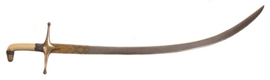 A FINE MUGHAL SHAMSHIR SABER: A superior example, the faceted steel pommel cap and guard thickly inlaid overall with gold in flowering vine motifs with silver wire wrap intact. The moderately-curved blade forged of fine, actively-