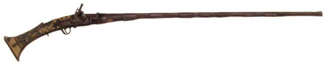 A MOROCCAN MUSKET: Of Taouzilt type, the hardwood stock of characteristic form, with flattened applied elephant butt and geometrical inlays throughout. Mounted with a well-made, locally-produced snaphaunce lock featurin
