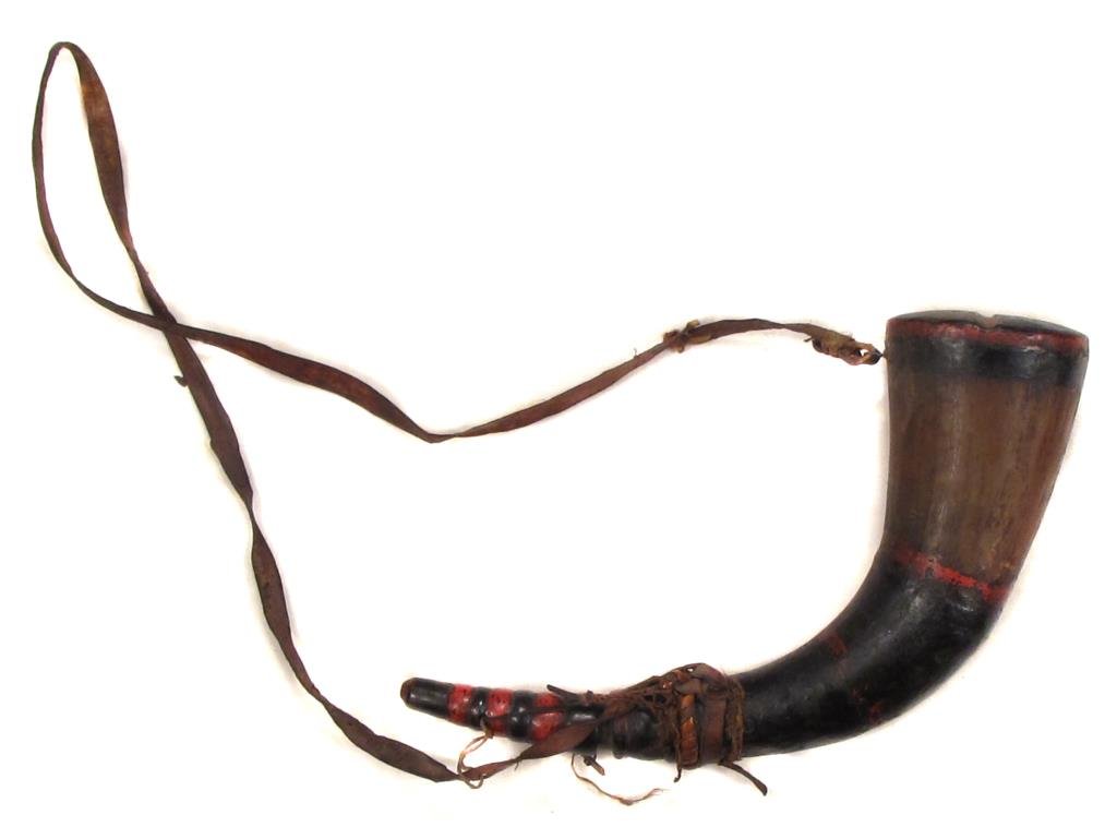 AN EAST ASIAN POWDERHORN: Likely Taiwanese, of carved horn, with painted bands. The cap acts as a measure. On its hide sling.Mid-19th century.Worn, leather torn.Overall length 31.5 cm. Condition II