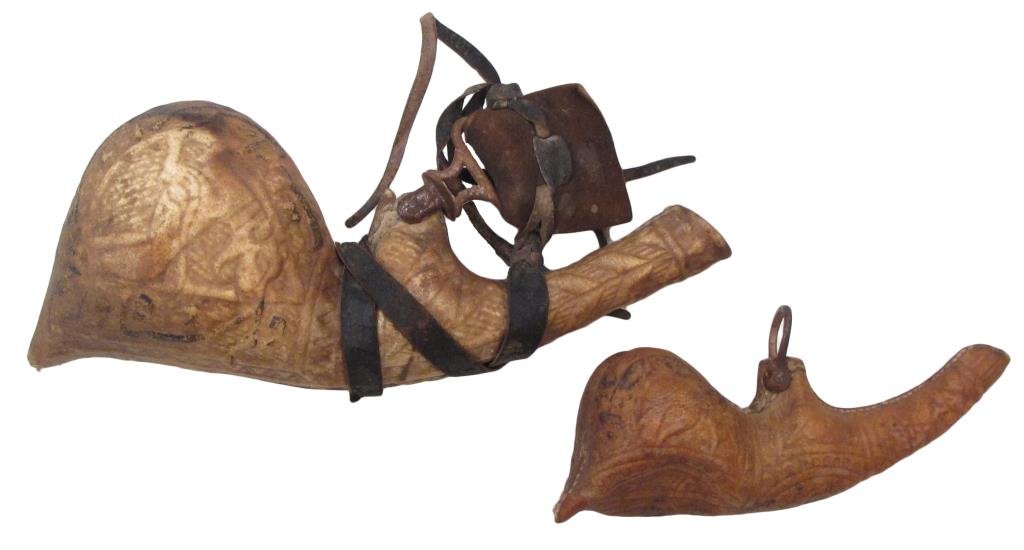 A MATCHING PERSIAN BARUTDAN POWDERHORN AND PRIMER: Of finely-tooled rawhide with geometrical motifs overall, together with hunting animals and Persian inscriptions. The horn retains a section of its strap. Mid 19th century. Overall length of the large