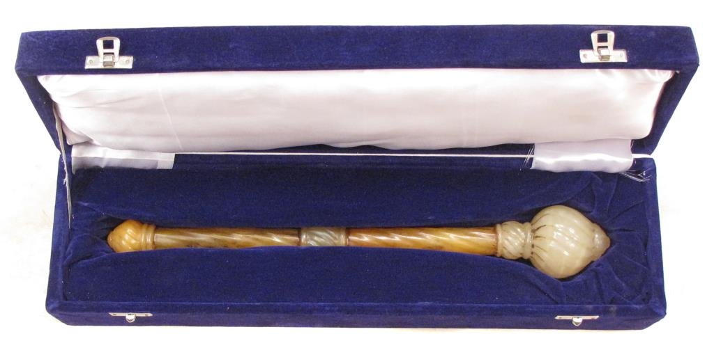 AN INDIAN COMMANDERâ€™S MACE: Composed of white jade and amber-colored stone, with graceful wrenched motif throughout, the onion-shaped head with elaborate finial. In a later fitted presentation case. 19th century. Traces of adhes