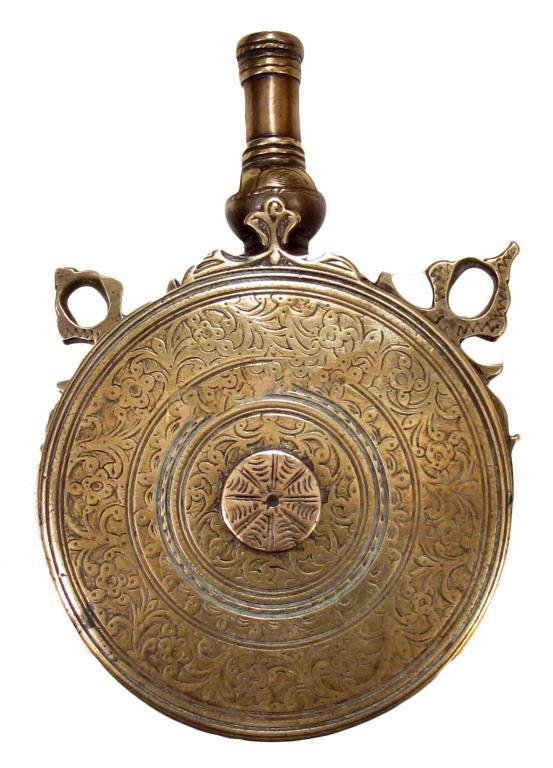 A MOROCCAN POWDER FLASK: Wrought of brass with finely engraved bands of decoration to each side, with profiled spout and lugs intact. Mid 19th century. Light wear. Overall length 15.5 cm. _x000D_ Condition II_x000D_
