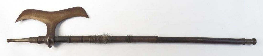 A RARE INDIAN BATTLEAXE: A form endemic to the Bhil people of Central India, the steel head forged with a convex bit, the socket wrought with a pronounced flange. On its hardwood haft with brass mounts and wire wrap. Latter 1
