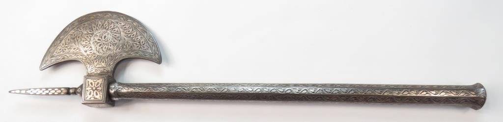 AN INDIAN BATTLEAXE: Of steel, with crescent head and spike finial and faceted haft. Lavishly inlaid overall in silver vinework. 20th century. Overall length 46 cm._x000D_ Condition I_x000D_
