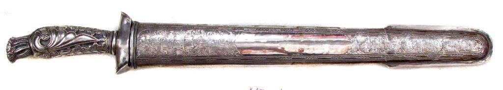 AN INDONESIAN PEDANG SWORD: Likely Javanese, the entire hilt of finely embossed and engraved silver. The single-edged blade of characteristic form forged of pattern-welded damascus steel. In its finely embossed and engraved silv