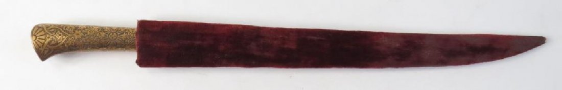 A MUGHAL KARD DAGGER: The grip wrought of steel and finely inlaid in gold flowering vine motifs overall, the single-edged blade with upswept tip forged of finely-patterned silver-gray wootz. In its silk-covered wooden scab