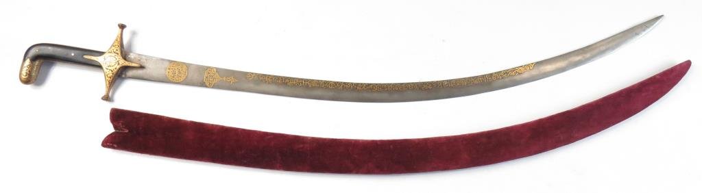 A MUGHAL SHAMSHIR SWORD: The persiform hilt with iron mounts finely inlaid with gold vegetal motifs on a russet ground. The wooden grips replaced, the tangbands inlaid with gold vinework en suite with the guard. The robust, c