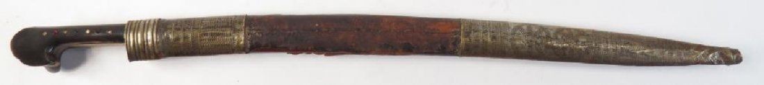 AN OTTOMAN YATAGHAN SWORD: Balkan work with polished horn grips set with faceted red glass stones and ribbed and embossed brass reinforces. The recurved blade inlaid on both sides in silver and inscribed, WORK OF IBRAHIM OWNERH