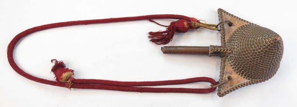 A MOROCCAN POWDERFLASK: A rare example of beehive form, wood with leather and extensive brass stud decoration overall. Retains its cap and woven suspension band. Mid-19th century. Light wear. Overall length 33.5 cm. Conditio