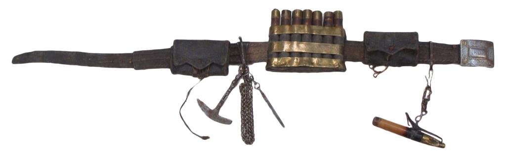 AN AFGHAN MUSKETEER€™S BELT: Of leather, with flasks, tools, priming horn and pouches, the fine steel buckle brass-inlaid and engraved overall. Latter 19th century. Worn. From the estate of Heinrich Harrer, Austrian mountaineer,