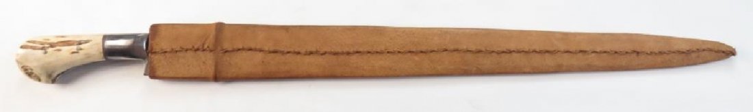 AN AFGHAN KHYBER KNIFE: A massive example, with staghorn grips and steel bolster, the broad blade highly polished. In its leather-covered wooden sheath. 20th century. Overall length 81.2 cm._x000D_ Condition I_x000D_