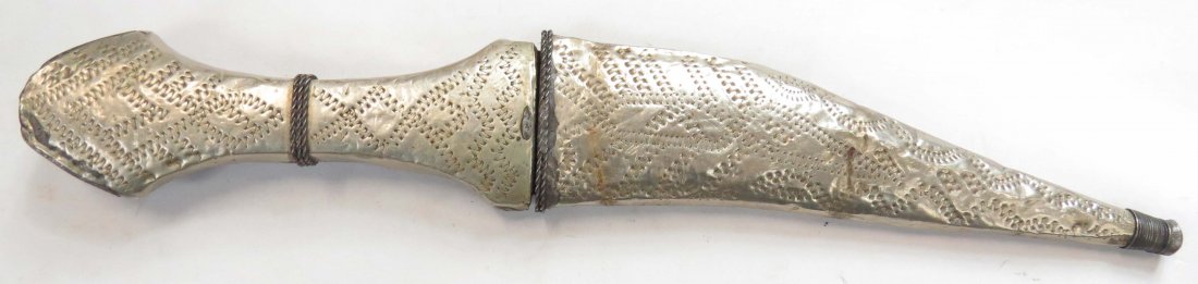 A SYRIAN KHANJAR DAGGER: With embellished white metal mounts and recurved blade. In its matching scabbard. Mid-20th century. Overall length 27.9cm. Condition III