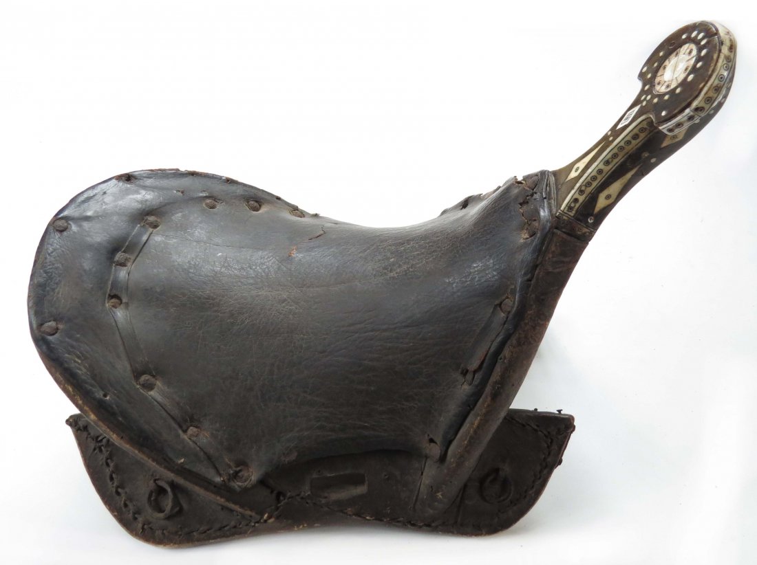 A RARE CENTRAL ASIAN NOMADIC SADDLE: Likely Kirghiz People, of wood, the crested pommel inlaid with bone in geometrical motifs, the seat of hide. Mid-19th century. Light wear. Overall length 39cm. Condition II.