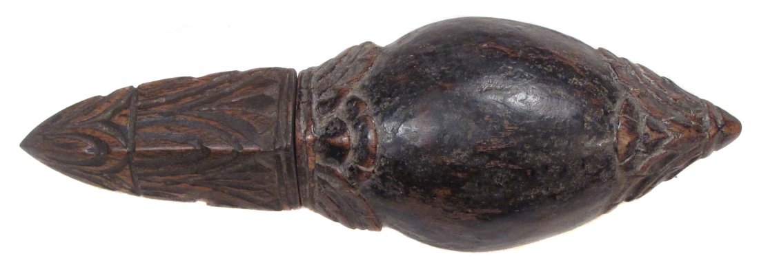 A SOUTHEAST ASIAN POWDER FLASK: A rare form, carved of dark hardwood with fitted cap and floral terminals. Mid-19th century. Light wear. Overall length 20.1 cm. Condition III