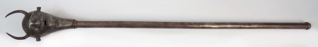 A PERSIAN QAJAR DYNASTY MACE: Of steel, wrought in the form of a devil’s head with prominent horns, eyes, ears and nose, on its steel haft. Latter 19th century. Weapons such as these were popular in Muharram Mourning ceremonies.
