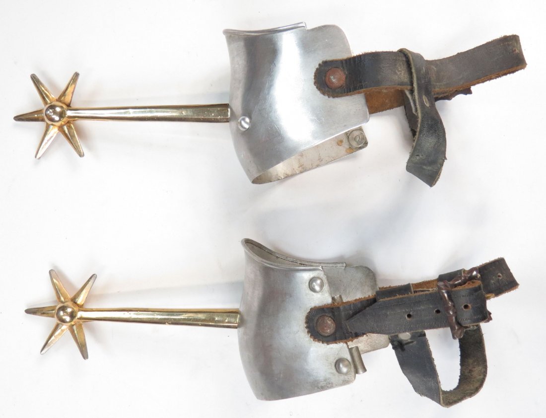 A PAIR OF VICTORIAN KNIGHTLY SPURS: With long, tapering, faceted shanks and six-pointed rowels, gilded overall. On their original steel armor heel plates with leather straps and profiled buckles. First half of the 19th century. Light we