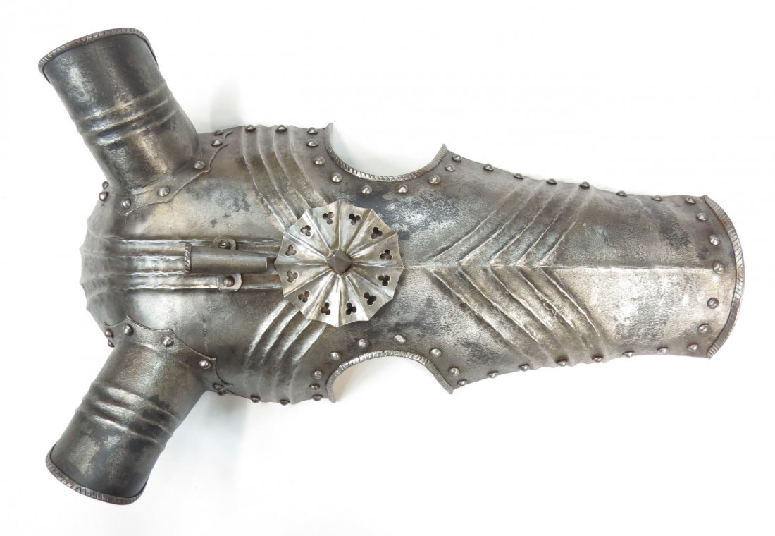 A VICTORIAN-ERA GOTHIC ARMOR CHANFRON: Well-wrought of steel with characteristic fluting and applied pierced central disk with projecting spike and eat guards, with roped borders throughout. 19th century. Light wear. Overall length 55cm. C