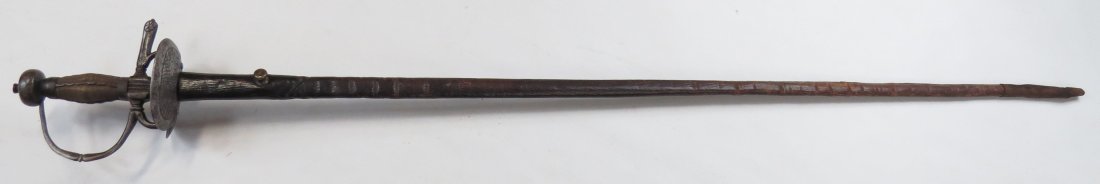 A SPANISH COLONIAL RAPIER SWORD: The hilt with flattened knucklebow, profiled at the center, developing into the pas d'anes and secured to the bilobate guard with two screws,and the fluted quillon block with single spatulate quillon 