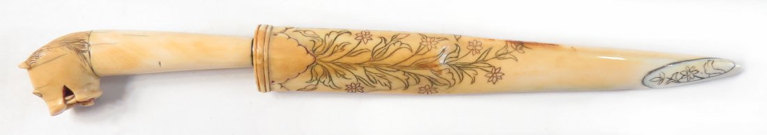 A FINE INDIAN TIGER-HEADED DAGGER: Mughal work, the entire hilt and scabbard of elephant, the pommel carved as a fully-modelled lion’s head with mane, ears and teeth well-delineated; the eyes gilded and the tongue retaining much orig
