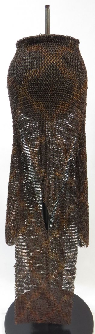 A MUGHAL MAIL COIF: Of higher quality than typically encountered, wrought or steel and brass rings in a geoletrical pattern. With characteristic triangular flap designed to protect the wearer’s face, a circular plate a