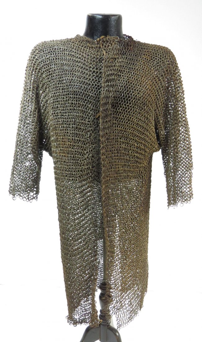 A RARE PERSIAN COAT OF MAIL: A heavy coat for a horseman, very well wrought of riveted rings throughout, with half sleeves and collar intact. Falls below the knee, with most rawhide edging intact. Early 17th century. Minor losses