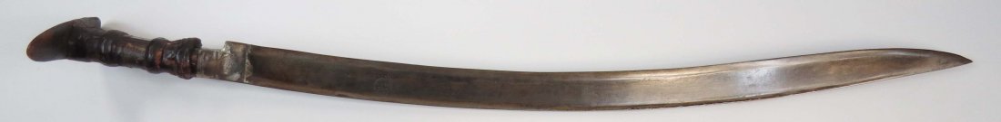 AN OTTOMAN YATAGHAN SWORD: A large example, the horn grips of Anatolian form, with leather bindings and brass reinforces and tangband. The blade of typical form, engraved with a short inscription. Worn. Overall length 75cm. Con
