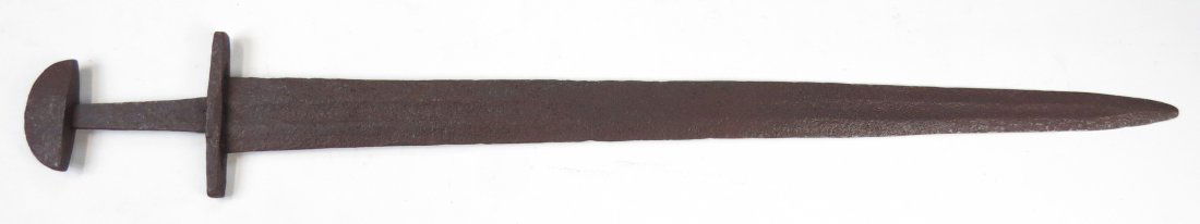 A VICTORIAN-ERA VIKING SWORD: Well-wrought in characteristic form with teacosy pommel, broad guard and continuously- tapering, fullered blade. 19th century. Corroded overall. Overall length 86.3cm. Condition IV