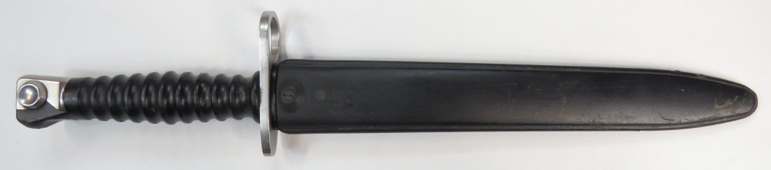 A SWISS ARMY BAYONET: Model 1957, with molded grip and polished blade, in original sheath. Mid-20th century. Light wear. Overall length 37.9cm. Condition II