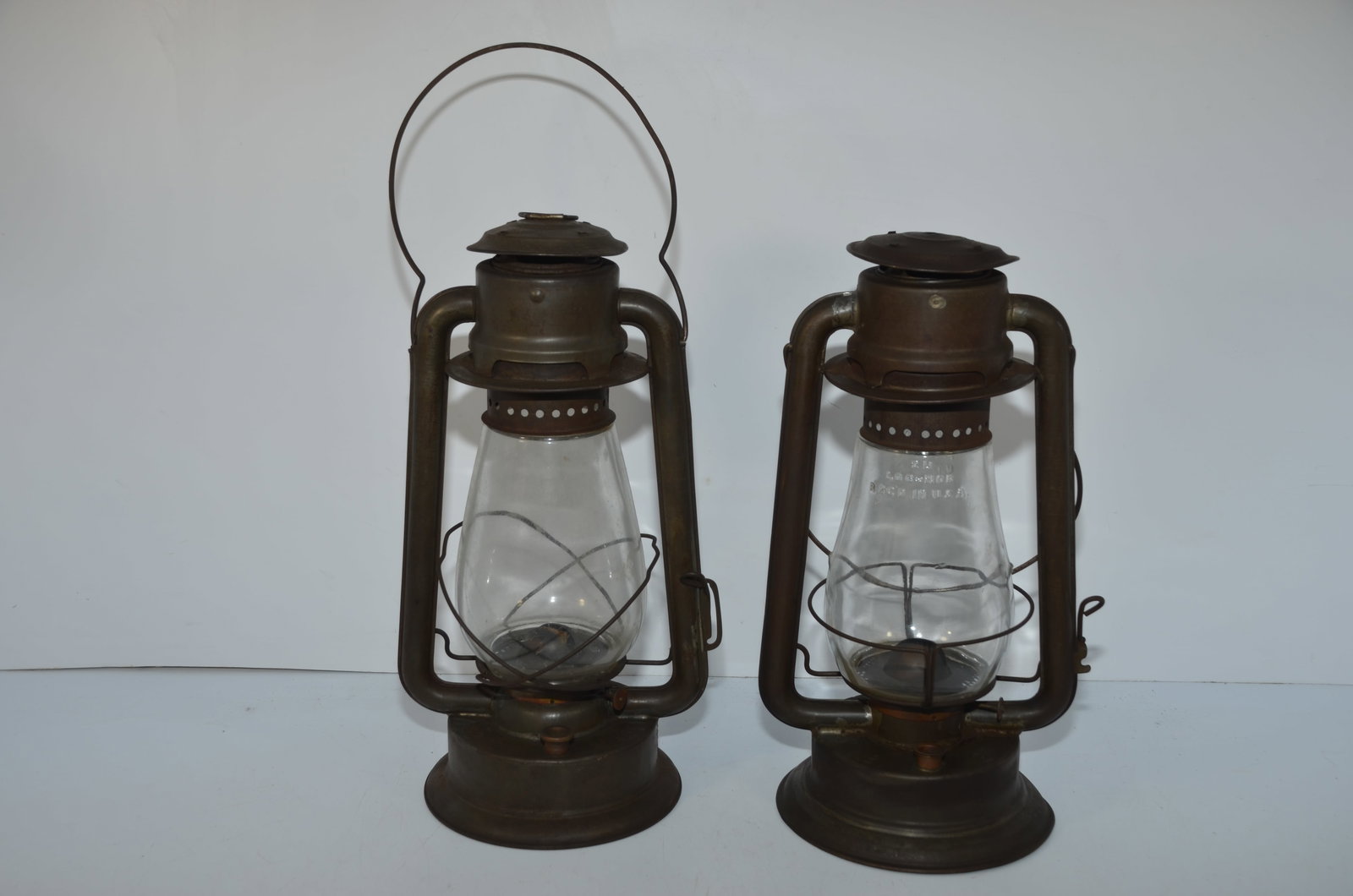 Two C T Ham Lanterns-#2 Cold Blast and #2: This is a pair of C T Ham lanterns. The first is highly desirable, and is cast with NO 2 COLD BLAST on the fount. Plain clear globe and correct burner. The second lantern is cast NO 2 on the fount. Ha