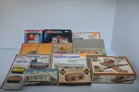 Mixed Lot of 12 HO Scale Buildings-New in Original Boxes: This is a mixed lot of 12 HO scale buildings, made by AHM, Lima, Life-Like, Plasticville, and Tyco. They include a police station, passenger station, drive through bank, windmill pumping station, brid