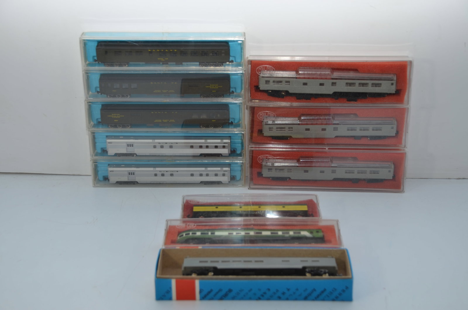 Ten Mixed N Scale Passenger Cars-New in Box: This is a mixed lot of N scale passenger cars, which are all new in their original boxes. Four are undecorated, while the others represent the Penn Central, Santa Fe, and Burlington Northern. There is