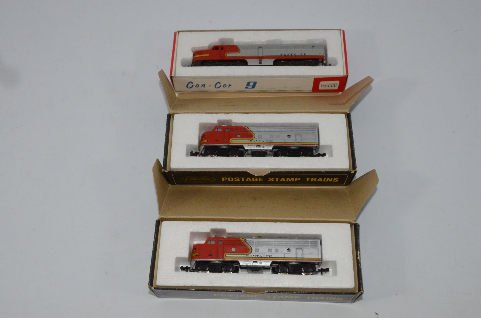 3 N Scale Santa Fe Diesel Locomotives: This is a lot of 3 N scale Santa Fe diesel locomotives. There in one made by Con-Cor and two from Aurora. Looking at the photo, the top and middle locomotive will need servicing to run well, while the