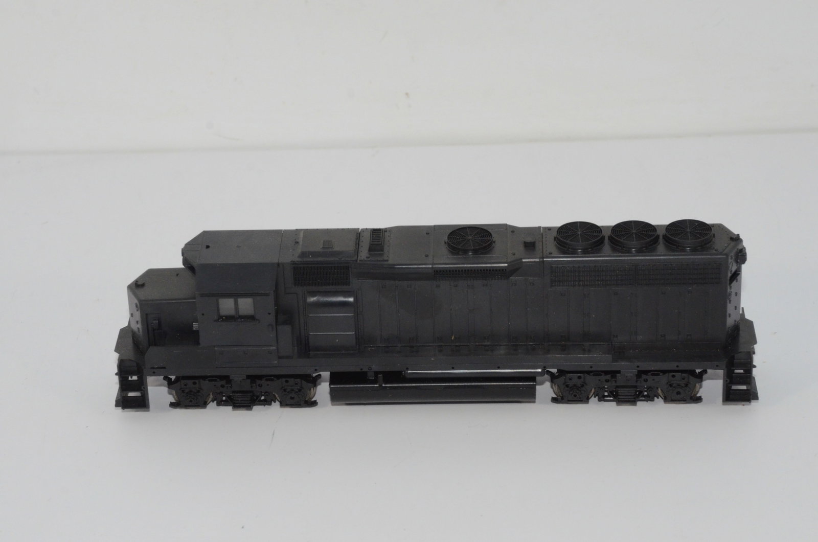 Two Used Diesel Locomotives-Athearn-HO Scale: This is a pair of used diesel locomotives, both in HO scale, and made by Athearn. Both have been tested and run. The first is an undecorated GP38. The handrails are in the bottom of the box, but it ne