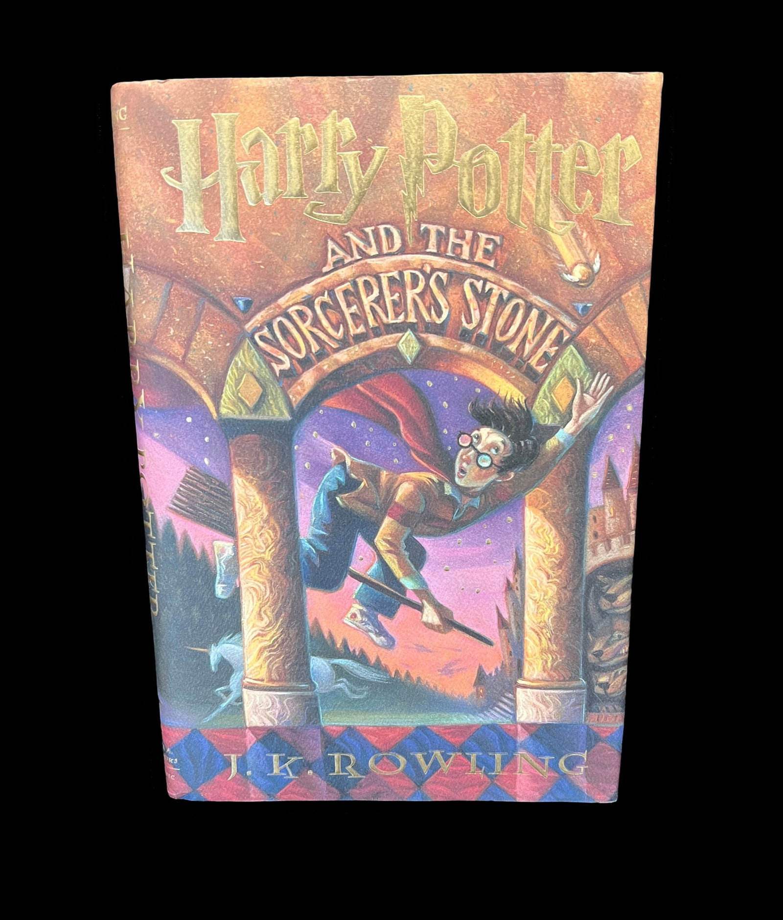Harry Potter and the Sorcerer’s Stone – First American Edition, October 1998 (Hardcover): Harry Potter and the Sorcerer’s Stone by J.K. Rowling, published by Scholastic. The book features a hardcover binding with a red cloth spine and purple embossed boards, along with gold foil letterin