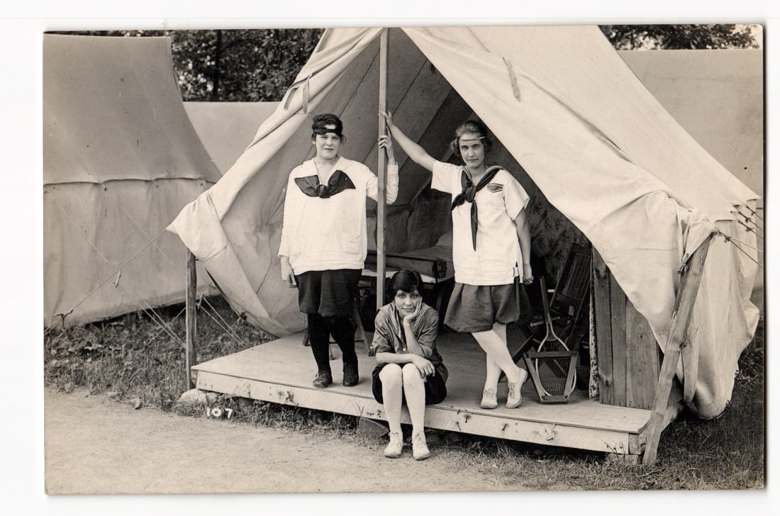 Real Photo Postcard: Three Young Women in Uniforms Posing at Tent Entrance, Camp Setting. (1 of 2)